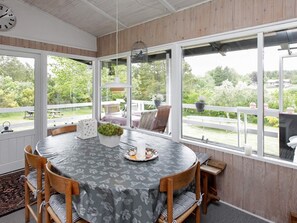 A dining area with a round table, chairs, and a view of the outdoors. - 4 Person Holiday Home in Hojslev (Hojslev)