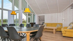 A modern interior with a dining area, sofa, and large windows. - Splendid Holiday Home in Jutland With Whirlpool (Sydals)