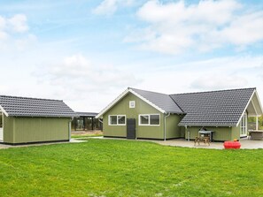 A row of green-roofed cabins with a grassy yard in front. - Splendid Holiday Home in Jutland With Whirlpool (Sydals)
