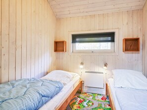 A room with two single beds, a window with blinds, and a radiator. - 5 Star Holiday Home in Nexo (Akirkeby)