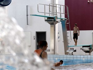 Een binnenzwembad met duikplanken en banen.
