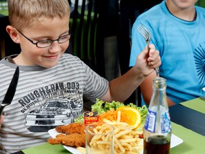 A dining table with a plate of food, a bottle of soda, and a fork. - 4 Star Holiday Home in Skaerbaek (Skaerbaek)