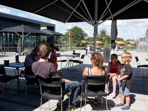 An outdoor seating area with tables and chairs under a shaded structure. - 4 Star Holiday Home in Skaerbaek (Skaerbaek)