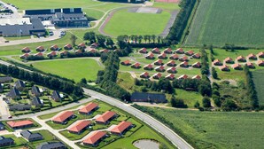 An aerial view of a residential area with multiple houses, a sports field, and a large building with a flat roof. - 4 Star Holiday Home in Skaerbaek (Skaerbaek)