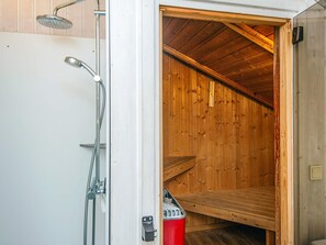 Un sauna aux murs en bois et au plafond incliné.