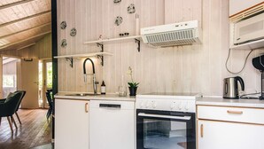 A kitchen with white cabinetry, a dishwasher, an oven, and a microwave. - 4 Star Holiday Home in Borkop (Borkop)