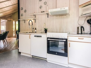 A kitchen with white cabinetry, a dishwasher, an oven, and a microwave. - 4 Star Holiday Home in Borkop (Borkop)