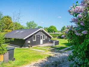 Een modern huis met een schuin dak, een terras en een verzorgd gazon.