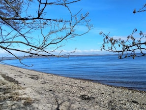 A beach with clear blue water and rocky shoreline.