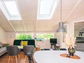 A modern interior with a dining area, a sofa, and a TV.