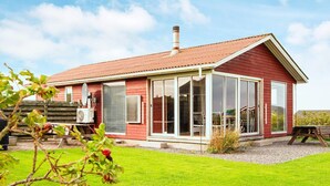 A red wooden house with a large glass front and a sloped roof. - 5 Person Holiday Home in Lemvig-by Traum (Lemvig)