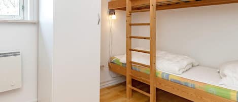 A bunk bed with a ladder, a window, and a white wall.