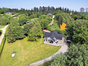 A residential area with multiple houses surrounded by dense greenery.