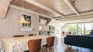 A dining area with a table covered in a polka dot tablecloth, surrounded by chairs with wooden legs.