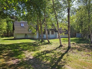A small, single-story building with a sloped roof, surrounded by trees and grass. - Swanky Seaside Holiday Home in Fur near Sea (Fur)
