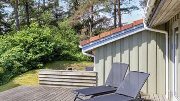 A wooden deck with two sun loungers and a small shed with a sloped roof.