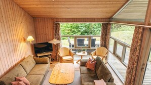A cozy living room with a wooden interior, a television, two sofas, a coffee table, and a view of the outdoors. - 5 Star Holiday Home in Hadsund (Hadsund)