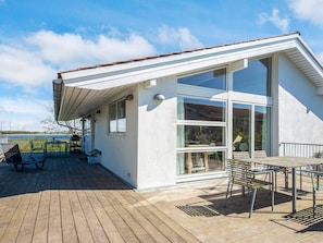 Een modern huis met een ruim terras, een overdekte patio en grote ramen.