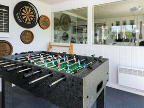 A foosball table in a room with dartboards on the wall. - Alluring Holiday Home in Hadsund near Sea (Hadsund)