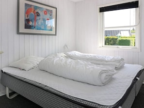A room with a bed, a window with a view of greenery, and a framed artwork on the wall. - Alluring Holiday Home in Hadsund near Sea (Hadsund)