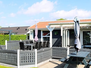 An outdoor patio area with tables and chairs, a covered seating area, and a view of a neighboring building. - Alluring Holiday Home in Hadsund near Sea (Hadsund)
