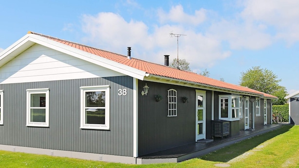 A two-story building with a grey exterior, white trim, and a red-tiled roof.