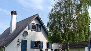 A white house with a chimney, a satellite dish, and a tree in the yard. - Cozy Holiday Home in Hemmet near Sea (Hemmet)