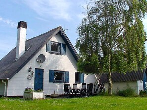 A white house with a chimney, a satellite dish, and a tree in the yard. - Cozy Holiday Home in Hemmet near Sea (Hemmet)