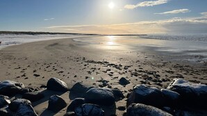A beach with large rocks in the foreground and a clear sky. - 4 Star Holiday Home in Blavand (Blavand)
