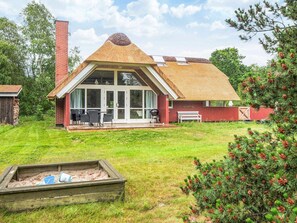 A house with a unique conical roof, large glass windows, and a patio area. - 4 Star Holiday Home in Blavand (Blavand)