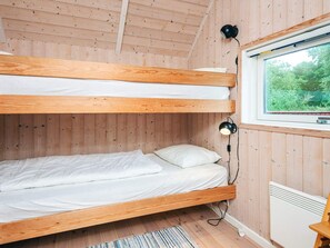 Une chambre avec un lit superposé, une fenêtre, un radiateur et une lampe.