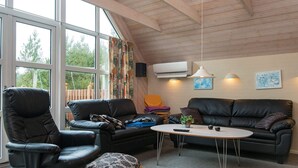 Ein modernes Wohnzimmer mit einer schwarzen Ledersofa, einem schwarzen Ledersessel und einem kleinen Holztisch.