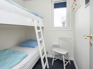 A bunk bed room with a ladder, a white chair, a window with blinds, and a door with a brass handle. - 5 Person Holiday Home in Lemvig (Lemvig)