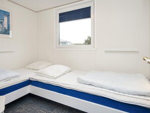 A single-bed room with a window, white walls, and a blue accent on the lower bed. - 5 Person Holiday Home in Lemvig (Lemvig)