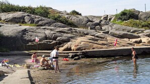 A rocky beach with people and a child near the water. - 4 Person Holiday Home in Brastad-by Traum (Brastad)