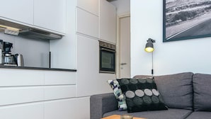 A modern kitchen with white cabinets, a coffee machine, and a wooden table with candles. - 4 Person Holiday Home in Romo (Rømø)