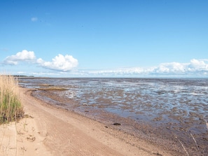 A beach with a sandy shore, a dirt path, and a distant view of the sea. - 4 Person Holiday Home in Romo (Rømø)