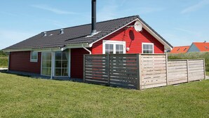 A red house with a black chimney, a wooden fence, and a clear blue sky. - Picturesque Holiday Home in LÃ¸kken near Sea (Lokken)