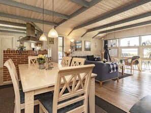 A spacious living area with a dining table, chairs, a sofa, and a view of the outdoors. - 5 Star Holiday Home in Oster Assels (Øster Assels)