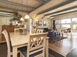 A spacious living area with a dining table, sofas, and a view of the outdoors. - 5 Star Holiday Home in Oster Assels (Øster Assels)