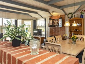A dining area with a brick table, chairs, a potted plant, and a glass vase. - 5 Star Holiday Home in Oster Assels (Øster Assels)