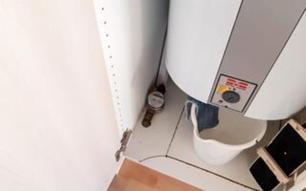 A bathroom with a toilet, bidet, and a control panel with a warning label.