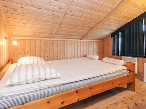 A wooden cabin bedroom with a bed, a window with curtains, and a wooden ceiling. - 5 Star Holiday Home in Hals (Hals)