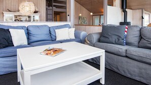 A modern living room with a white coffee table, two sofas, and a fireplace. - 4 Star Holiday Home in Henne (Henne)