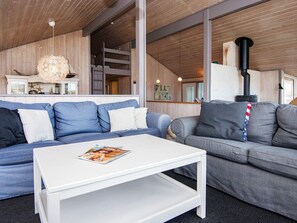 A modern living room with a white coffee table, two sofas, and a fireplace. - 4 Star Holiday Home in Henne (Henne)