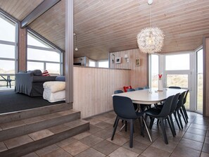 Un intérieur moderne comprenant un coin repas, un canapé et un escalier.