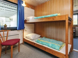 A bunk bed with a desk and chair, a window with blinds, and a small table with a lamp. - 8 Person Holiday Home in Spottrup (Spøttrup)