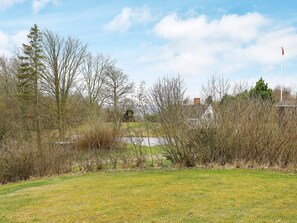 A grassy field with trees and a building in the background. - 8 Person Holiday Home in Spottrup (Spøttrup)