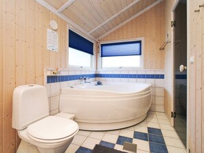 A bathroom with a toilet, a bathtub, and a window with blinds.