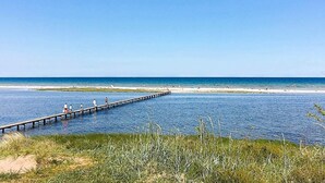 A pier extending into calm waters with people walking along it. - Unique Seaside Holiday Home in Hadsund near Terrace (Hadsund)